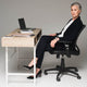 Mature businesswoman sitting near gadgets and papers on table on grey background