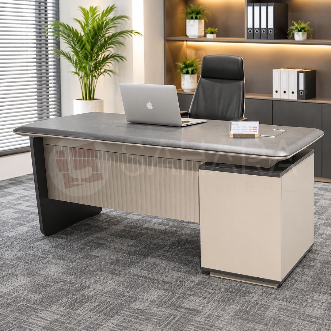 Bureau de direction 140 × 70 cm avec caisson latéral, plateau gris anthracite et façade décorative rainurée.
