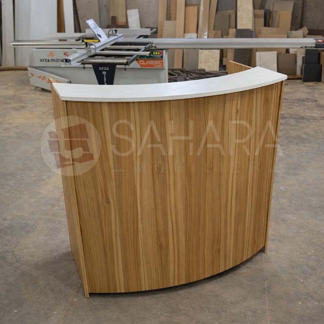 Ce comptoir d’accueil au design courbé est idéal pour les espaces professionnels souhaitant offrir une image moderne et élégante. Sa façade en bois avec plateau supérieur blanc crée un contraste esthétique parfait pour les zones de réception, bureaux ou showrooms.