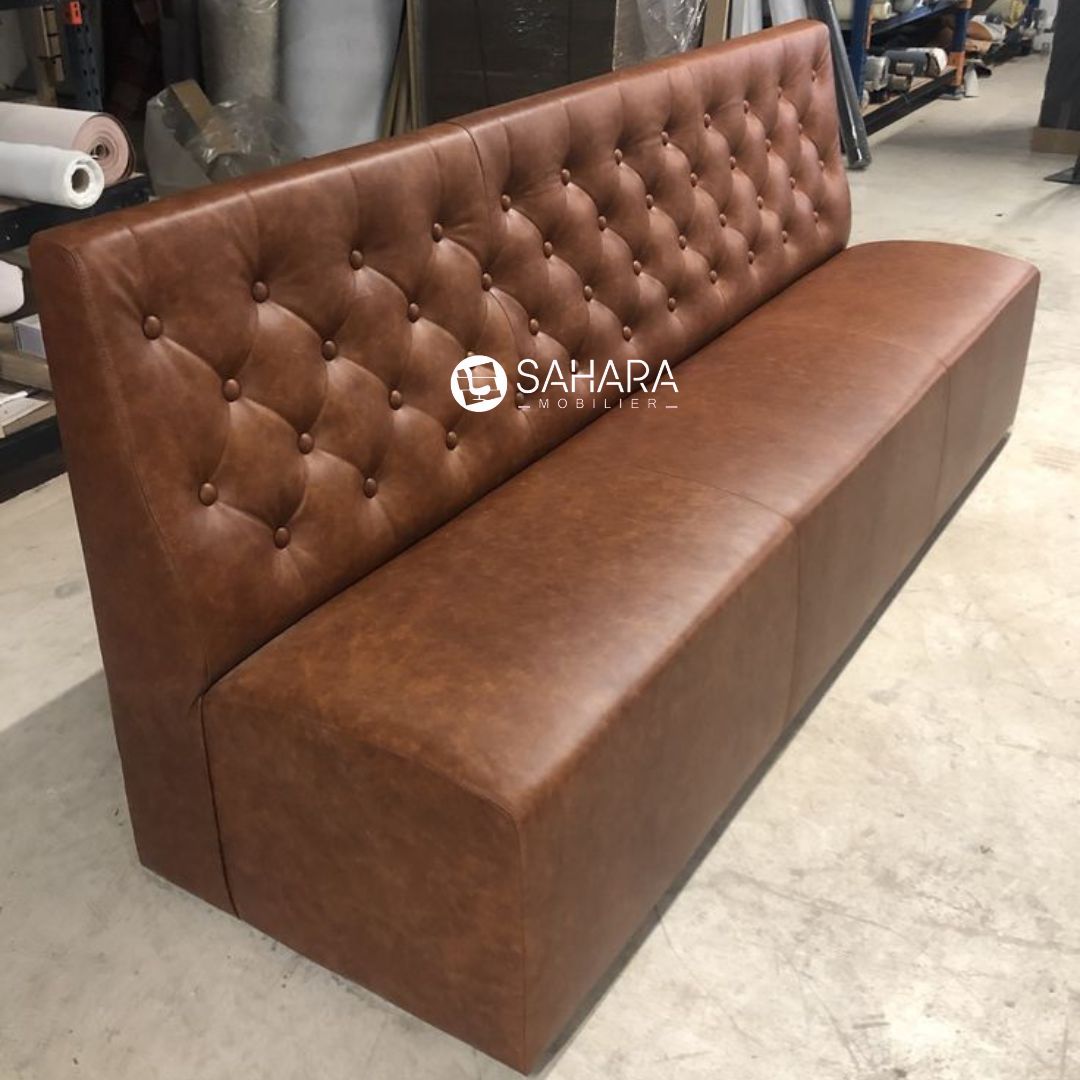 Fauteuil en simili cuir brown avec des bottons sur le dossier 